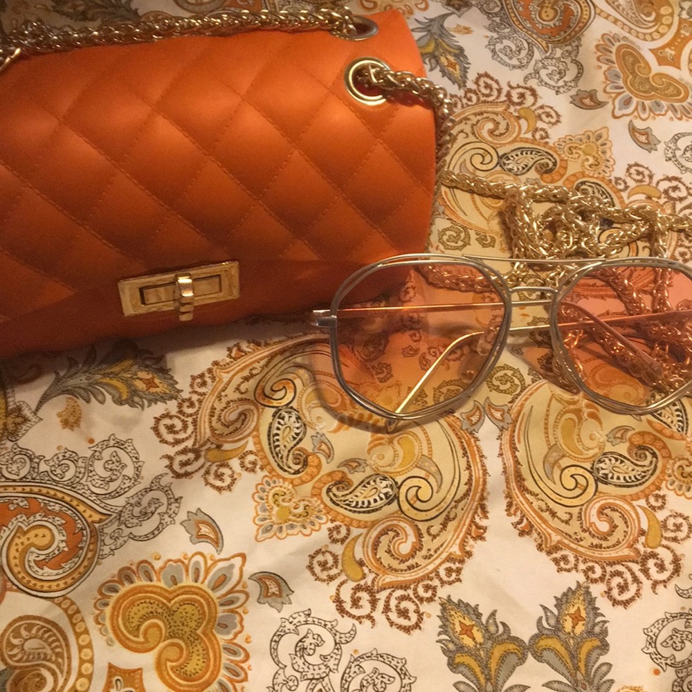 Orange delexury hang purse  a pair of sunglasses
